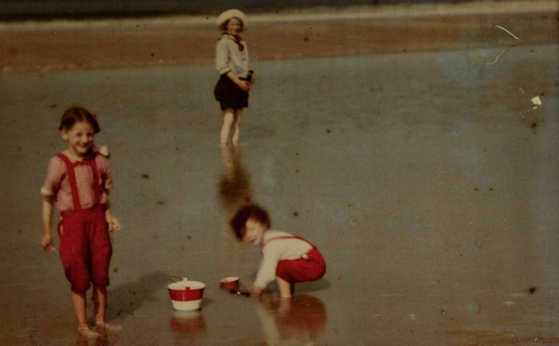 Photo. Drie kinderen spelend aan het Noordzeestrand, Adolphe Burdet (circle of), 1907 – 1930 Copyright: Public Domain